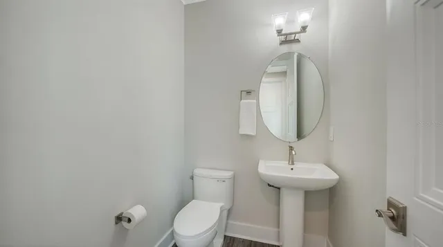 a bathroom with a sink toilet and a mirror