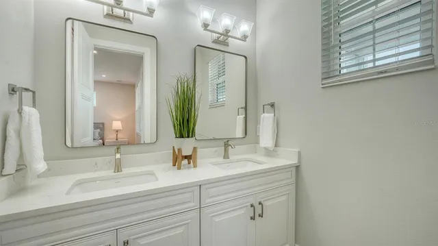 a bathroom with double vanity sink and a mirror