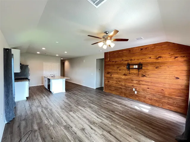 a view of a living room with hardwood floor and a ceiling fan