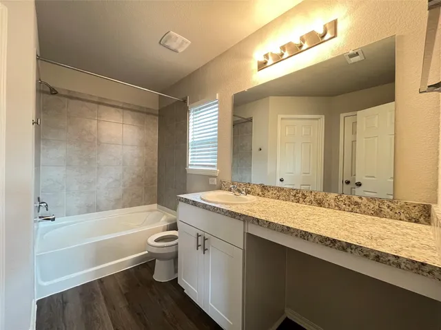 a bathroom with a granite countertop sink toilet and shower