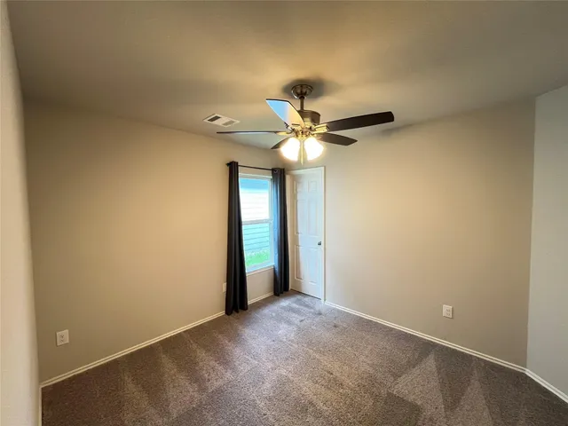 a view of an empty room with a ceiling fan