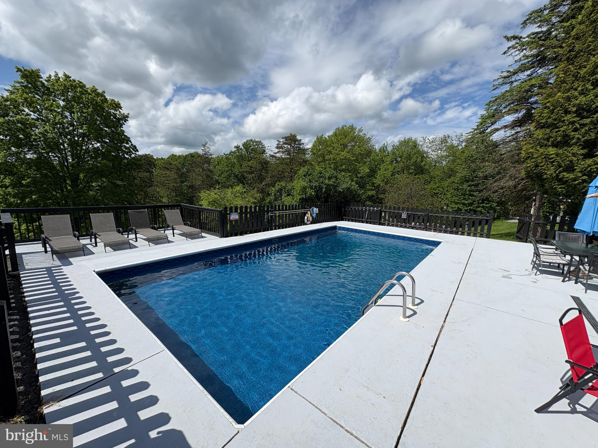 13644 Upper Corners Road Hesston, PA 16647 - Photo 21 of 28 Serene poolside retreat amidst lush greenery.