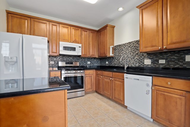 770 Lambert Lane, Unit 966 Bartlett, IL 60103 - Photo 13 of 33 a kitchen with stainless steel appliances granite countertop a refrigerator a stove a sink and a microwave