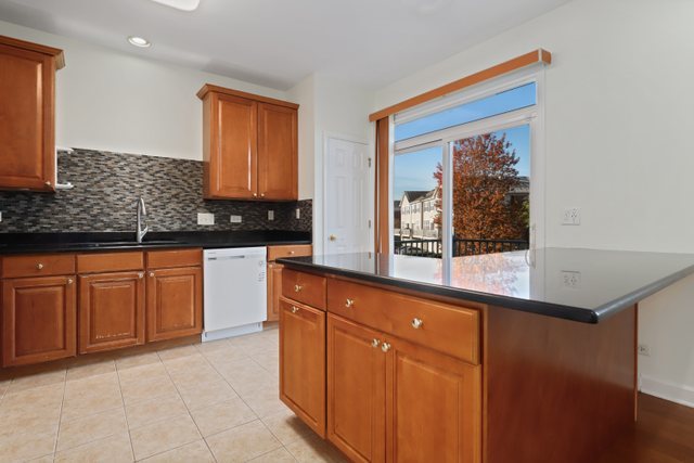770 Lambert Lane, Unit 966 Bartlett, IL 60103 - Photo 15 of 33 a kitchen with granite countertop cabinets and window