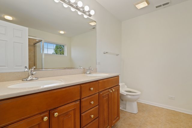 770 Lambert Lane, Unit 966 Bartlett, IL 60103 - Photo 19 of 33 a bathroom with a toilet sink and mirror