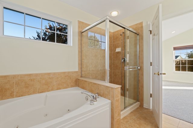 770 Lambert Lane, Unit 966 Bartlett, IL 60103 - Photo 20 of 33 a bathroom with a bathtub and a shower