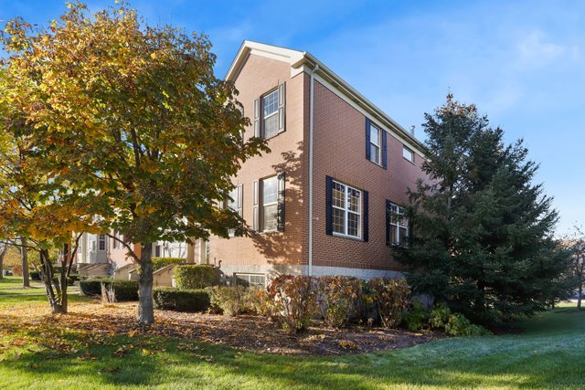 770 Lambert Lane, Unit 966 Bartlett, IL 60103 - Photo 3 of 33 a front view of a house with a garden and trees