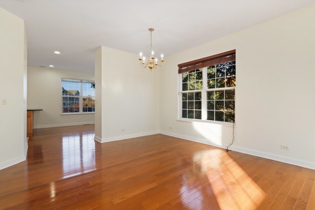 770 Lambert Lane, Unit 966 Bartlett, IL 60103 - Photo 8 of 33 a view of an empty room with wooden floor and a window
