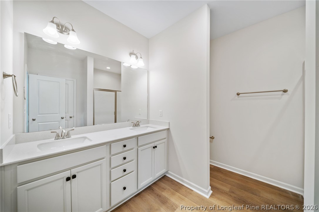 4044 Lofton Street Wade, NC 28395 - Photo 11 of 33 a bathroom with a double vanity sink and mirror