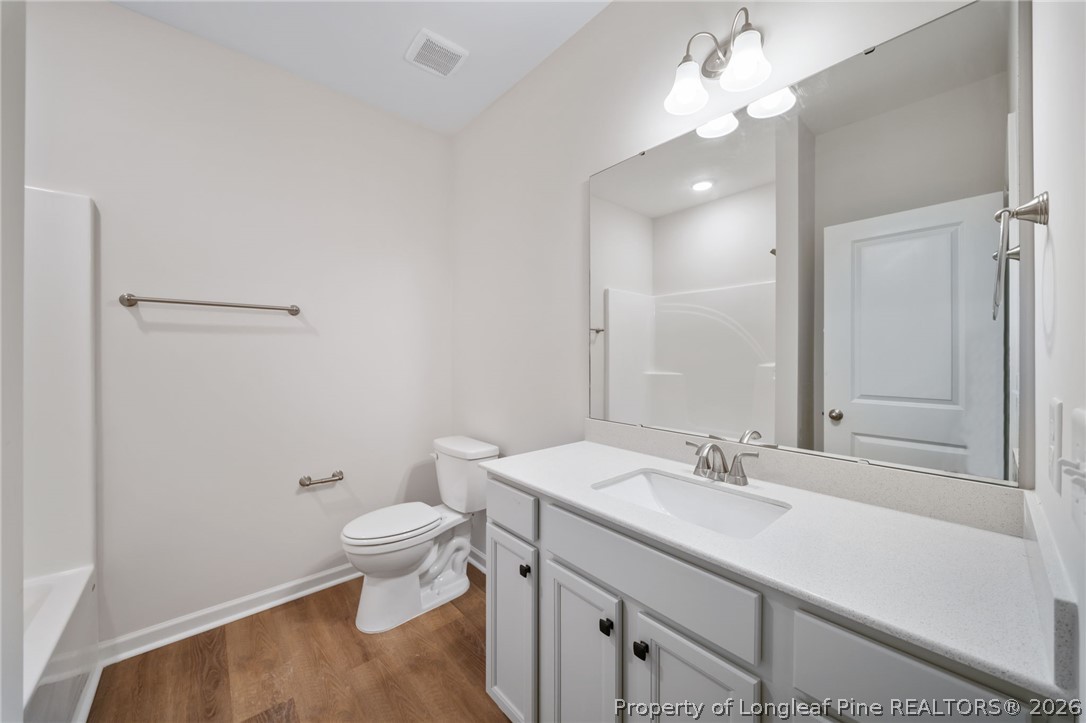 4044 Lofton Street Wade, NC 28395 - Photo 20 of 33 a bathroom with a sink a toilet and a mirror