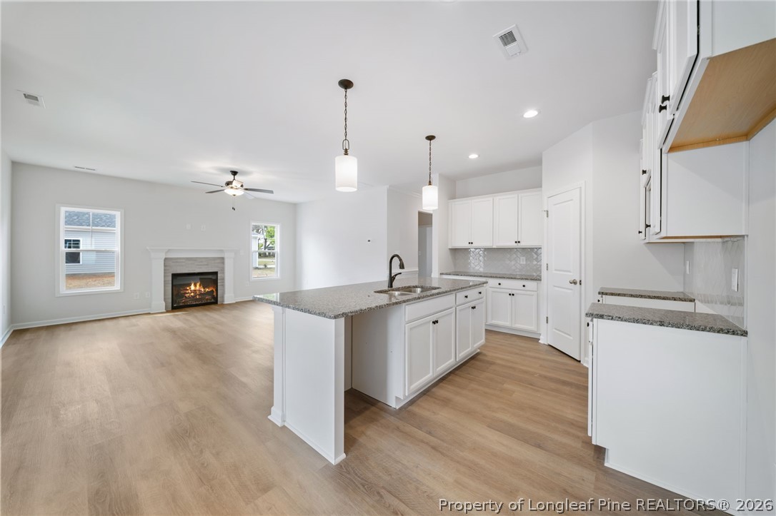 4044 Lofton Street Wade, NC 28395 - Photo 6 of 33 a large kitchen with cabinets wooden floor and stainless steel appliances