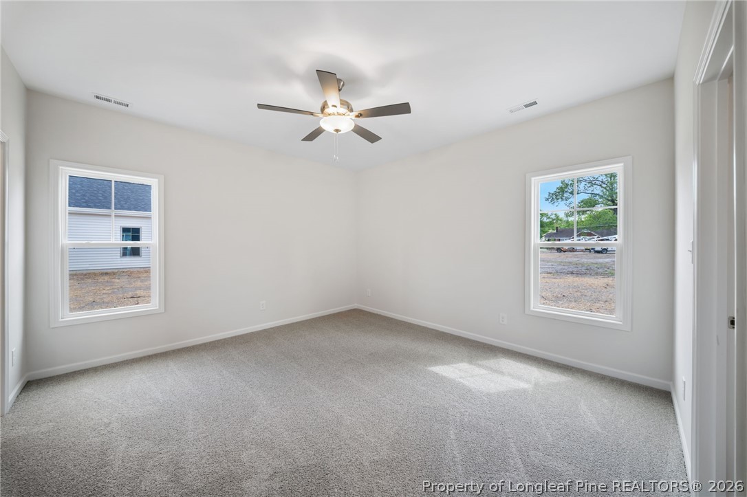 4044 Lofton Street Wade, NC 28395 - Photo 9 of 33 an empty room with a window and a fan