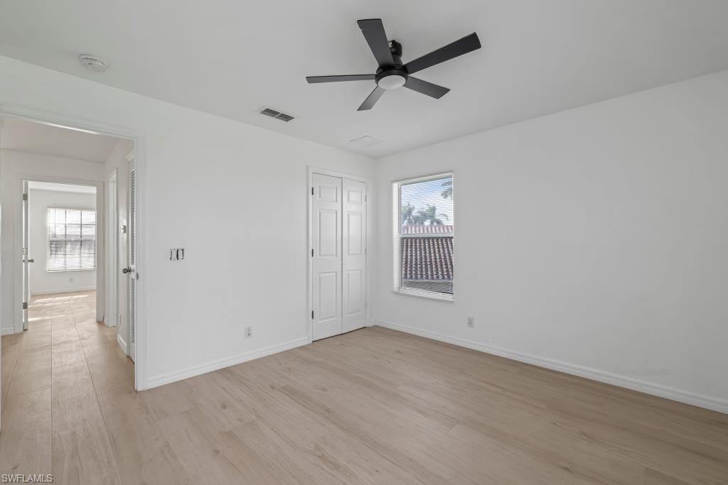 Undisclosed Address Naples, FL 34120 - Photo 15 of 24 Unfurnished bedroom with light wood-style floors, a ceiling fan, and a closet