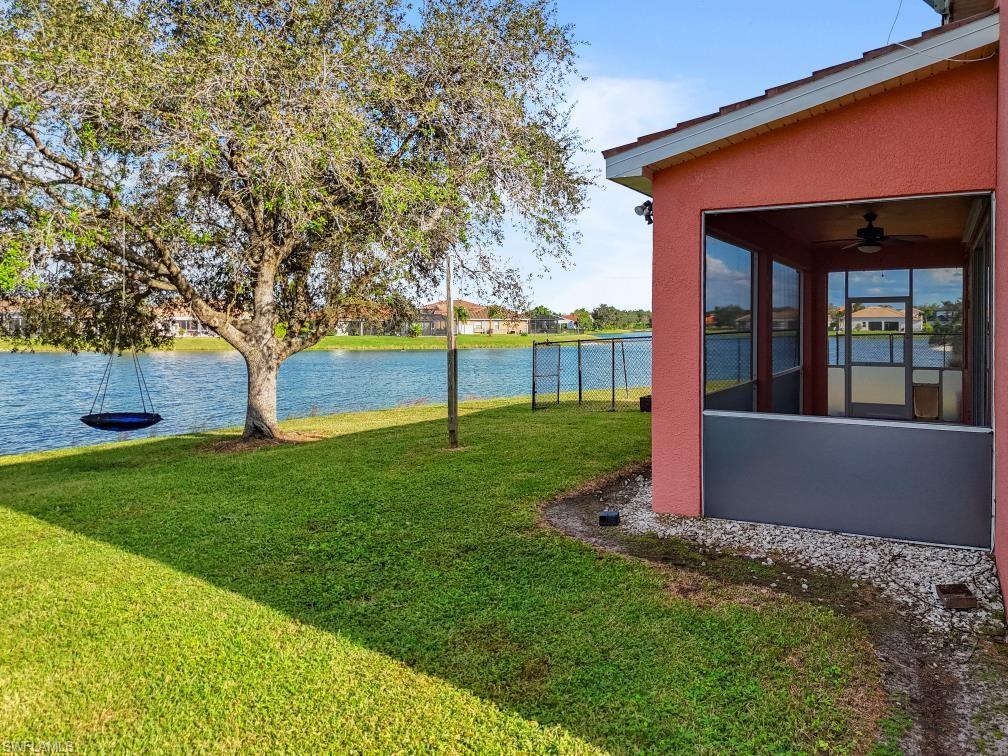 Undisclosed Address Naples, FL 34120 - Photo 4 of 24 View of grassy yard featuring a water view, a ceiling fan, and a sunroom