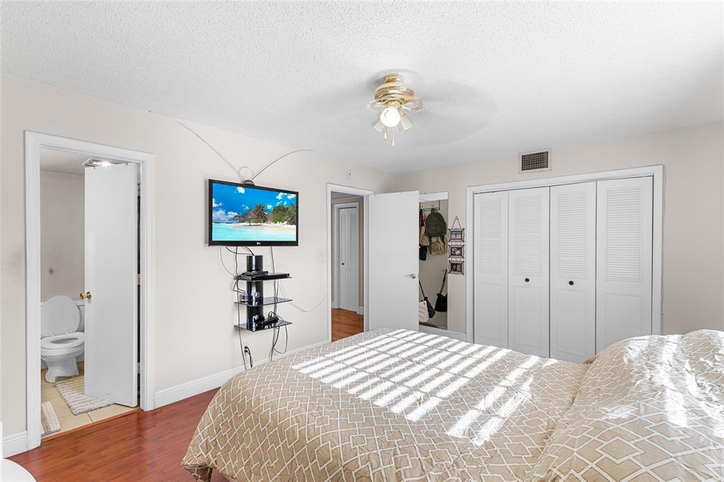 7556 Stirling Road, Unit 222 Hollywood, FL 33024 - Photo 21 of 48 a bedroom with a bed and a chandelier
