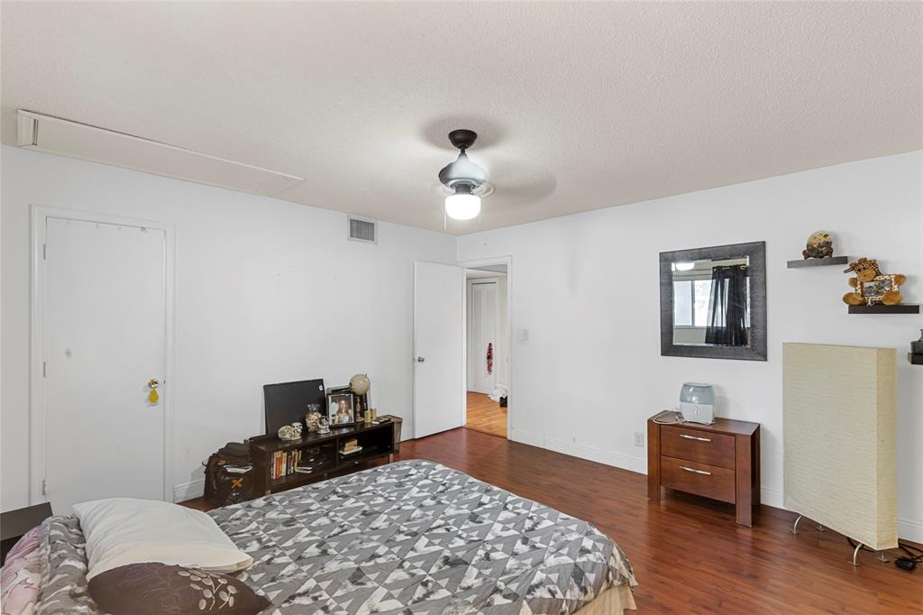 7556 Stirling Road, Unit 222 Hollywood, FL 33024 - Photo 8 of 48 a bedroom with a bed and wooden floor