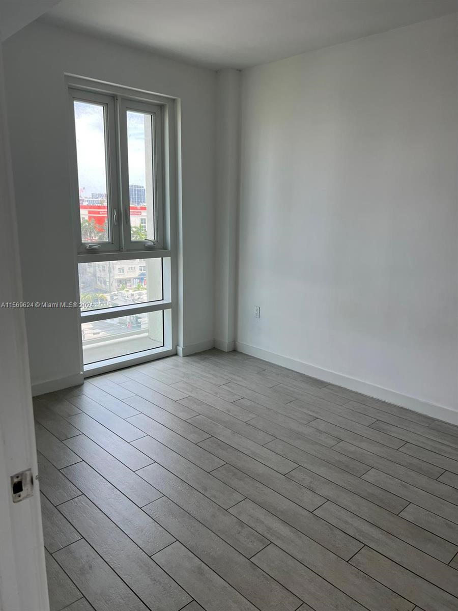 321 Northeast 26th Street, Unit 712 Miami, FL 33137 - Photo 2 of 8 wooden floor in an empty room with a window