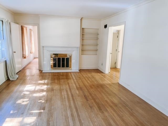 5208 Gwynne Road Memphis, TN 38117 - Photo 2 of 12 a view of a livingroom with wooden floor and a fireplace