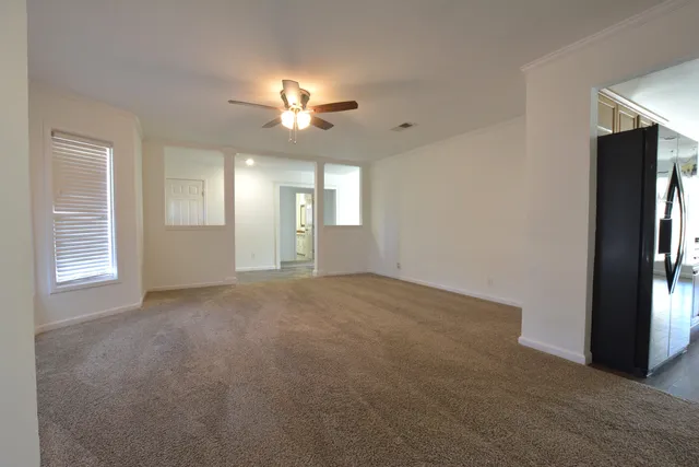 a view of a livingroom with a ceiling fan and window