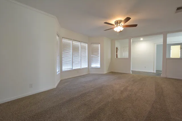 a view of an empty room with a fireplace and a window