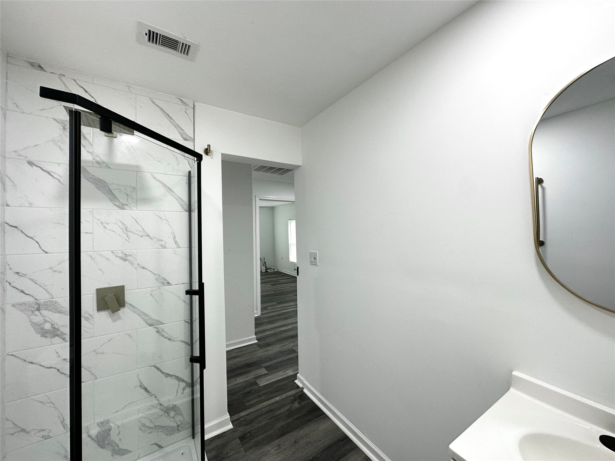 4318 1st Street, Unit C Bacliff, TX 77518 - Photo 11 of 14 a bathroom with a glass shower door and a mirror