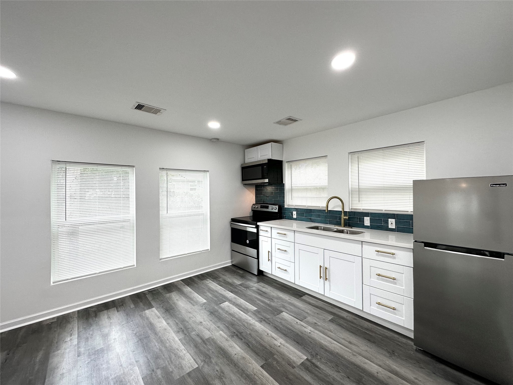 4318 1st Street, Unit C Bacliff, TX 77518 - Photo 4 of 14 a kitchen with granite countertop a refrigerator stove sink and cabinets