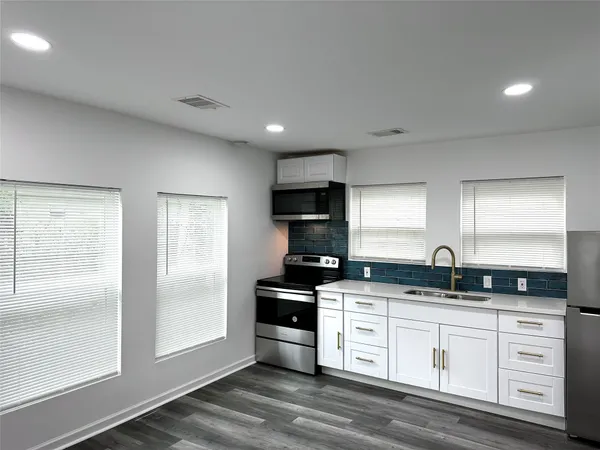 a kitchen with granite countertop a sink and cabinets