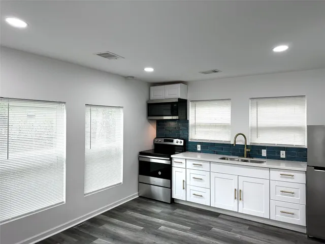 a kitchen with granite countertop a sink and cabinets