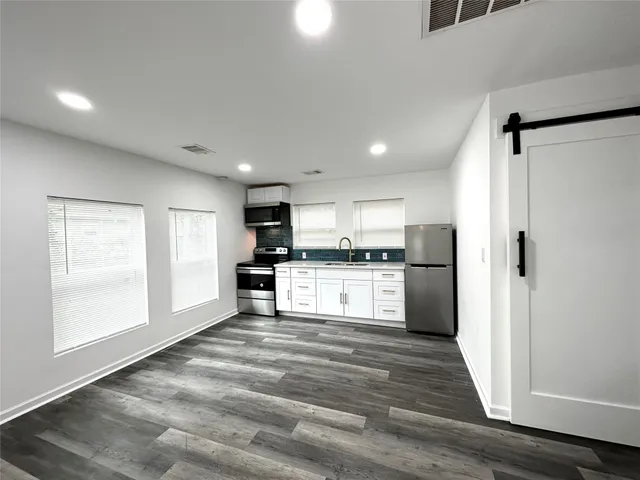 a kitchen with refrigerator and cabinets