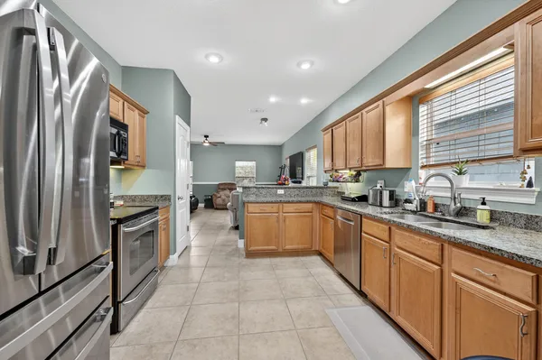 a kitchen with granite countertop a stove sink and cabinets
