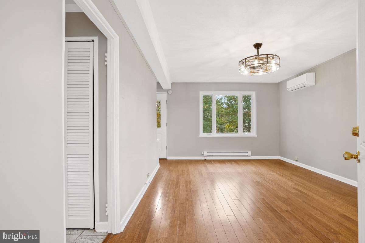 33 Ridge Road Greenbelt, MD 20770 - Photo 2 of 29 an empty room with wooden floor chandelier fan and windows