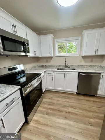 a kitchen with stainless steel appliances granite countertop a stove a sink and a microwave