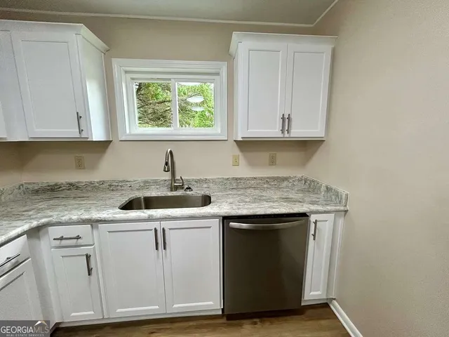 a kitchen with granite countertop cabinets sink and window