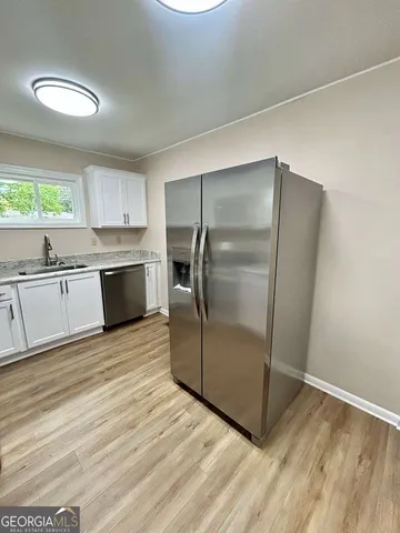 a kitchen with granite countertop a refrigerator and a sink