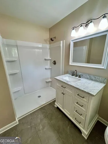 a bathroom with a granite countertop sink mirror and bathtub