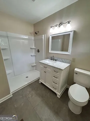 a bathroom with a double vanity sink mirror and toilet