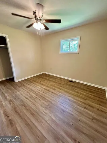 a view of an empty room with wooden floor