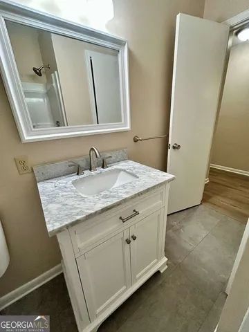 a bathroom with a granite countertop sink and a mirror