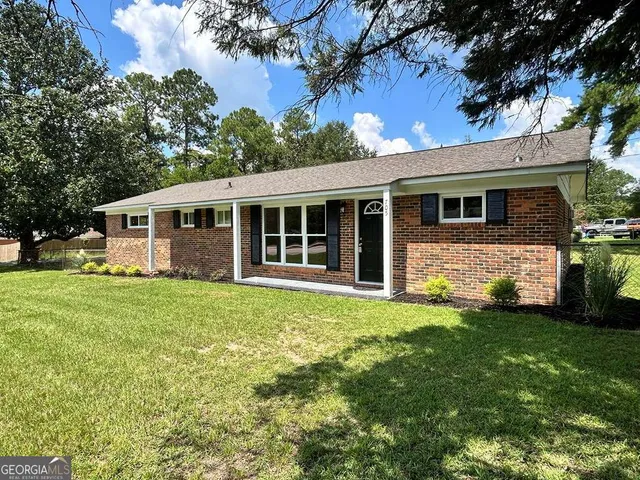 a view of a house with a backyard