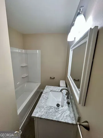 a bathroom with a sink a mirror and a bath tub