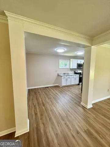 a view of empty room with wooden floor