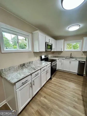 a kitchen with stainless steel appliances granite countertop a stove a sink and a microwave