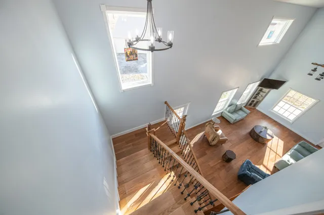 a kitchen with granite countertop a refrigerator oven a sink dishwasher and white cabinets with wooden floor