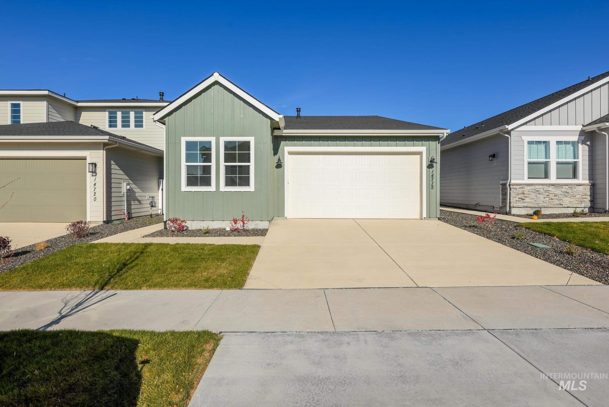 View of front of home featuring board and batten siding, concrete driveway, and an attached garage