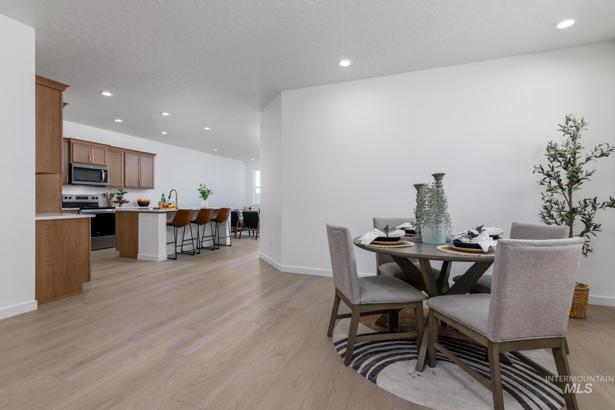 14742 Wing Spread Drive Caldwell, ID 83607 - Photo 6 of 10 Dining space featuring recessed lighting, light wood-style flooring, and a textured ceiling