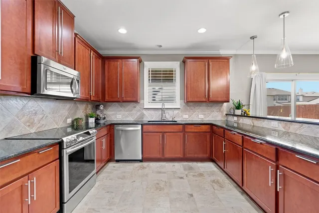 a kitchen with stainless steel appliances granite countertop wooden cabinets a sink and dishwasher
