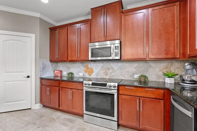 a kitchen with stainless steel appliances granite countertop wooden cabinets and a stove top oven