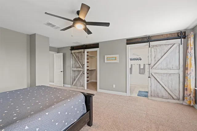 a bed room with a bed and a ceiling fan