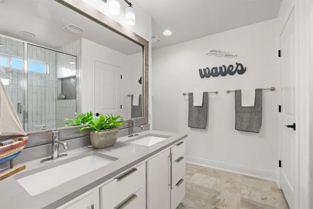 a bathroom with a sink a mirror and potted plant