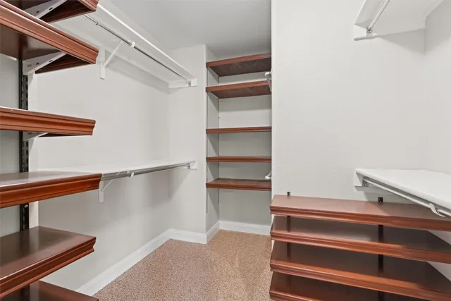a view of walk in closet with empty racks